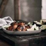 chipotle honey chicken plated with honey glaze, fresh cilantro, and lime wedges